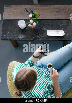 Ansicht von oben der jungen Frau mit Handy und Espresso in einem Café Stockfoto