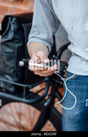 Nahaufnahme des jungen Mann mit Fahrrad mit Handy Stockfoto