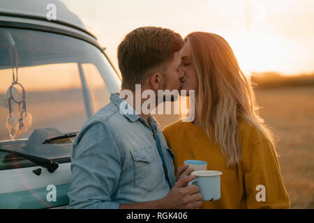 Junges Paar Küssen an Wohnmobil in ländlichen Landschaft Stockfoto