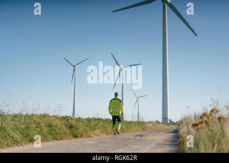 Ingenieur gehen auf Feld Pfad zu einem Windpark Stockfoto