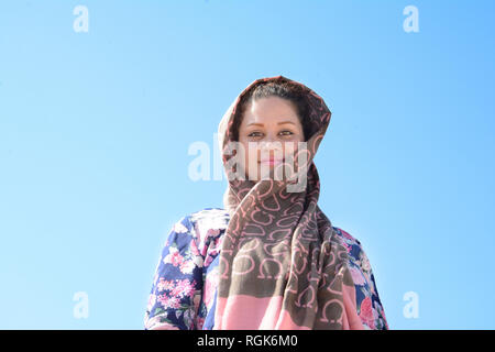 Porträt einer jungen Frau mit Kopftuch vor blauem Himmel Stockfoto