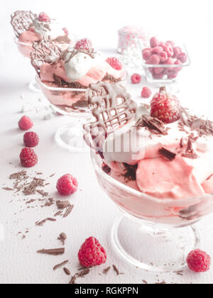 Drei Schokolade Himbeere Cloud Desserts in einer diagonalen Reihe mit Schlagsahne - Fotografie Stockfoto