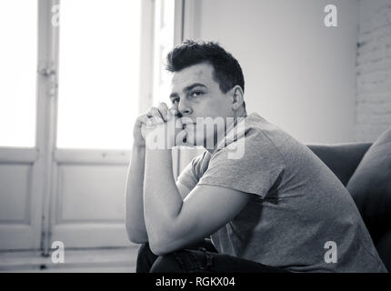 Portrait des jungen Mannes felling deprimiert und hoffnungslos allein weinend in Sofa home Leiden emotionalen Schmerz und Unglück. In den Leuten gebrochenes Herz, Bull Stockfoto