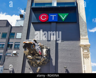 Skulptur von Nachrichten Lkw aus der Wand brechen, CTV (City TV) Gebäude (1913), Queen Street West, Toronto, Ontario, Kanada Stockfoto