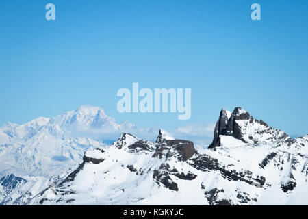 Tolle Aussicht auf dem Gipfel der Berge in den Alpen im Winter Ski Saison, mit den Wolken im Hintergrund und einem klaren sonnigen blauen Himmel Stockfoto