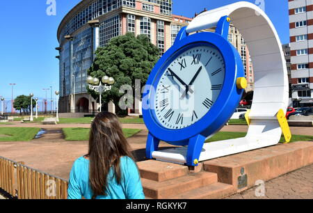 Frau suchen zu der Zeit in eine riesige Uhr. Öffentlicher Park in der Nähe von Strand Riazor. La Coruna, Spanien, 22. Sep 2018. Stockfoto