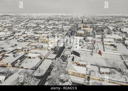 Antenne drone Ansicht der Stadt mit Schnee bedeckt. Straßen und Häuser im Winter aus der Vogelperspektive. Stockfoto