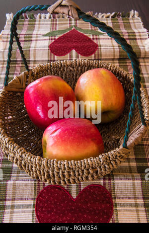 Äpfel in einem Korb auf einem Küchentisch. Stockfoto