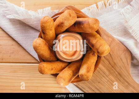 Blick von oben auf die Lateinamerikanische Vorspeisen namens Tequeños aus gebratenen Mais mit Käse gefüllt mit einem rosa Sauce Stockfoto