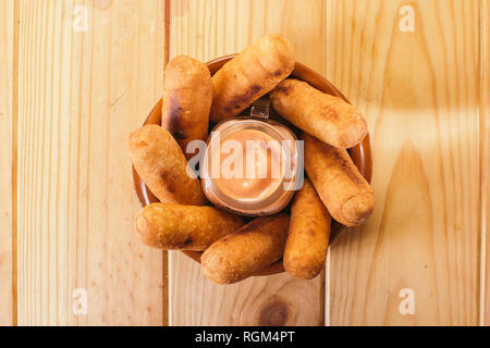 Blick von oben auf die Lateinamerikanische Vorspeisen namens Tequeños aus gebratenen Mais mit Käse gefüllt mit einem rosa Sauce Stockfoto