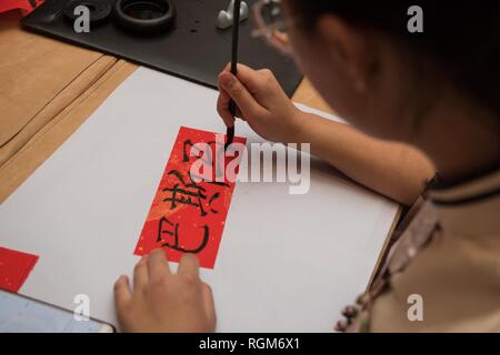 Alexandria, Ägypten. 28 Jan, 2019. Eine Arbeitsgruppe Personal schreibt arabische Name des Besuchers in chinesischen Schriftzeichen auf ein Fest feiern die chinesische Frühlingsfest in Alexandria, Ägypten, Jan. 28, 2019. Ägyptischen und chinesischen Volk Samstag freudige Feierlichkeit statt durch das chinesische Generalkonsulat in Alexandria gemeinsam die anstehenden Chinesischen Frühlingsfest beginnt am 5. Februar dieses Jahres zu markieren. Credit: Meng Tao/Xinhua/Alamy leben Nachrichten Stockfoto