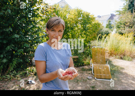 Portrait von lächelnden Frau mit Granatapfel Samen Stockfoto