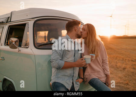 Junges Paar Küssen an Wohnmobil in ländlichen Landschaft Stockfoto