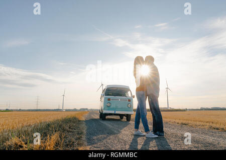 Junges Paar Küssen an Wohnmobil in ländlichen Landschaft Stockfoto