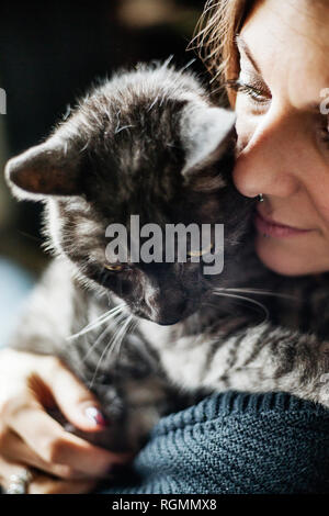 Frau umarmte ihre grauen Tabby cat Stockfoto