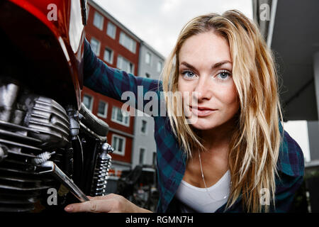 Portrait von selbstbewussten jungen Frau, die auf dem Motorrad Stockfoto