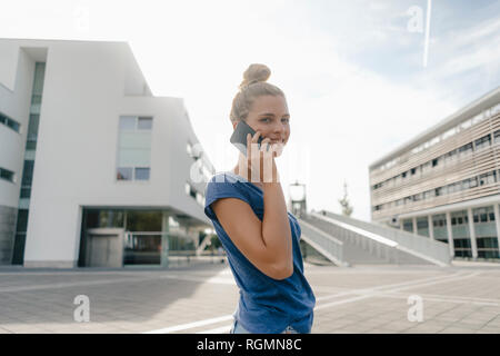 Niederlande, Maastricht, lächelnden jungen Frau auf Handy in der Stadt Stockfoto