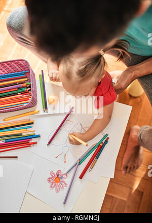 Kleines Mädchen zeichnen mit Buntstift, während ihr Vater sie beobachten, Ansicht von oben Stockfoto
