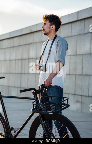 Junger Mann mit Pendler fixie Bike und Kamera um suchen Stockfoto