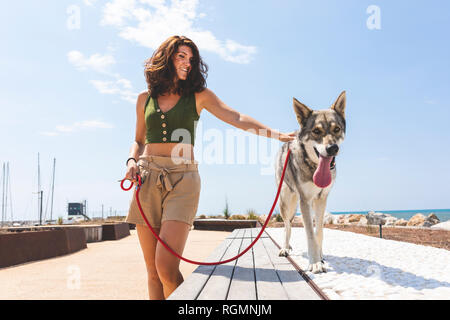Junge Frau mit ihrem Hund Gassi gehen Stockfoto
