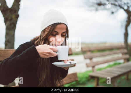 Porträt der jungen Frau trinkt Kaffee im Freien Stockfoto