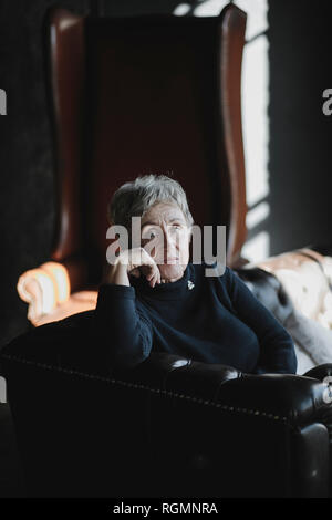 Porträt von senior Frau sitzt auf der couch Stockfoto