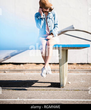 Entspannt junge Frau sitzt auf Tischtennis Musik hören Stockfoto