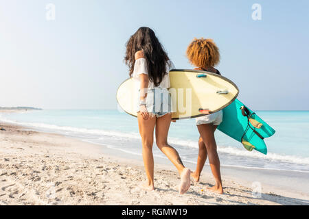 Freunde zu Fuß am Strand, Surfbretter Stockfoto