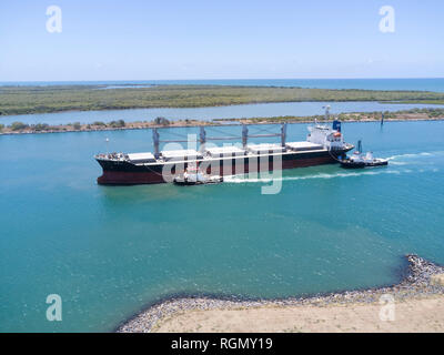 Antenne bulk carrier Schiff am Burnett River Liegeplatz an der Sugar Terminal mit Hilfe von zwei Schleppern Port Bundaberg Queensland Australien Stockfoto