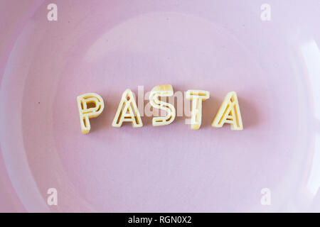 Das Wort "Pasta" mit echten pasta Buchstaben in einem rosa Schale. Close Up. Stockfoto