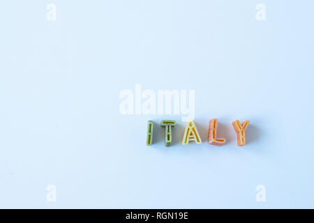 Das Wort "Italien" besteht aus echten pasta Buchstaben in die italienische Flagge Farben auf eine weiße Fläche. Hintergrund mit Kopie Raum auf der linken Seite. Stockfoto