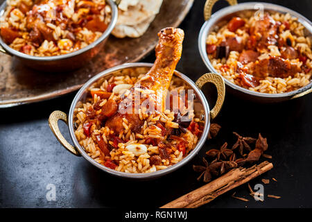 Die einzelnen Portionen von würzigen Arabischen kabsa mit langen feinkörnigen Reis, Gemüse und Fleisch mit getrockneten Sternanis und Zimt Zutaten neben Stockfoto