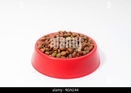 Rot Schüssel mit trockenem Futter für Katzen oder Hunde auf weißem Hintergrund mit Platz für Text Stockfoto