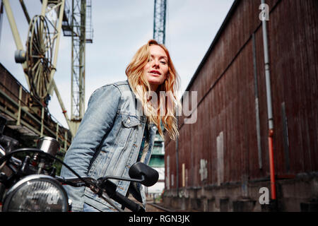 Portrait von selbstbewussten jungen Frau, die auf dem Motorrad Stockfoto