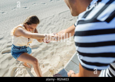 Mann, Frau, die vom Strand zu klettern Stockfoto