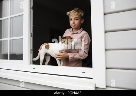 Porträt der jungen mit Jack Russel Terrier Blick aus Fenster öffnen Stockfoto