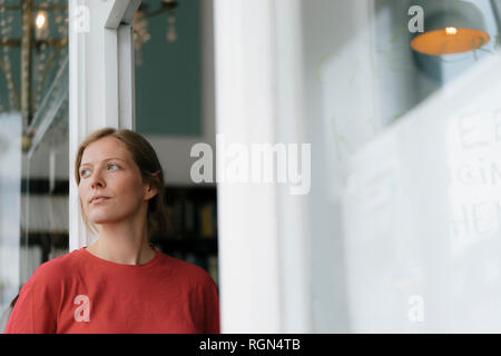 Junge Frau von französischen Tür in ein Cafe um suchen Stockfoto