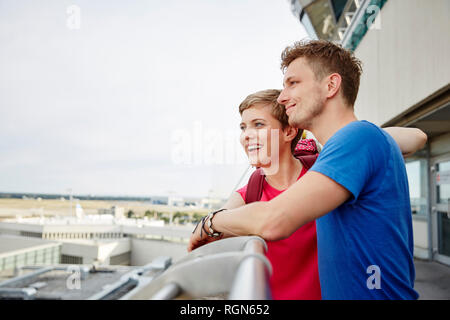 Glückliches Paar auf der Aussichtsplattform am Flughafen Stockfoto