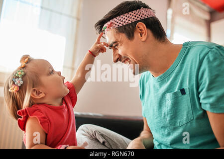 Vater und kleine Mädchen sich gemeinsam amüsiert zu Hause Stockfoto