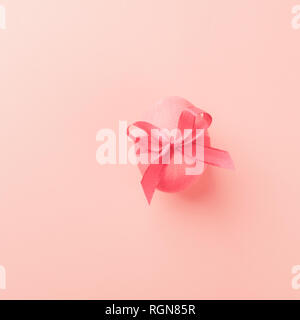 Osterei auf eine trendige Coral Farbe Hintergrund. Festliche Konzept. Minimalismus. Kopieren Sie Platz. Selektive konzentrieren. Quadratischen Rahmen. Blick von oben. Flache Layout. Stockfoto