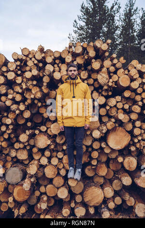 Junger Mann, stehend auf einem Stck Holz, wodurch die Illusion des Schwebens Stockfoto