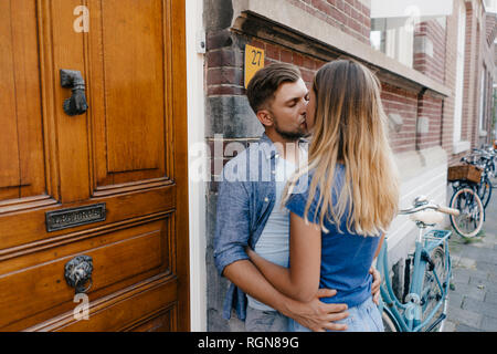 Liebevolle junge Paar Küssen in der Stadt Stockfoto