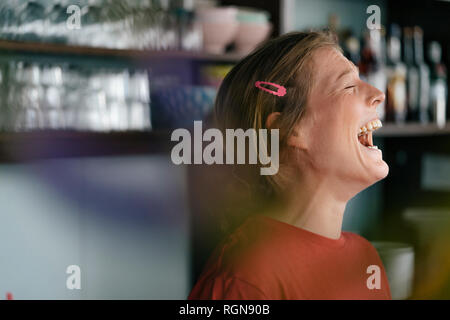 Lachende junge Frau in einem Cafe Stockfoto