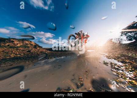 Motocross Fahrer fahren durch das Wasser, spritzen Stockfoto