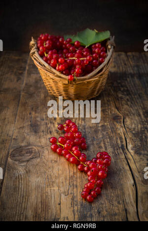 Rote Johannisbeeren im Warenkorb auf Holz Stockfoto