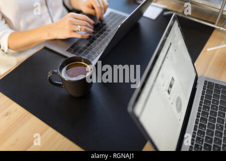 In der Nähe von Frau mit Laptop auf dem Schreibtisch im Büro Stockfoto