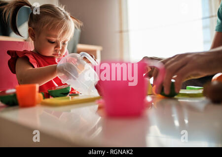 Kleine Mädchen spielen zusammen mit ihrem Vater zu Hause Stockfoto