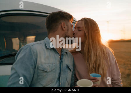 Junges Paar Küssen an Wohnmobil in ländlichen Landschaft Stockfoto