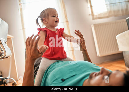 Kleine Mädchen spielen mit ihrem Vater zu Hause Stockfoto