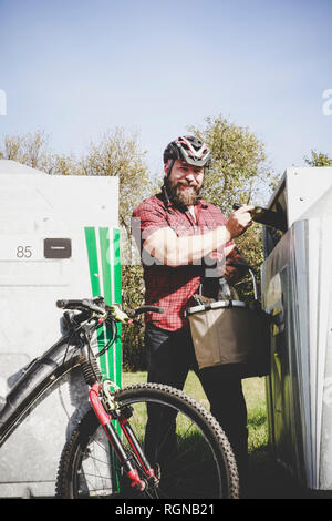 Portrait von Mann recycling Glas Flasche Flasche Radfahrer Stockfoto